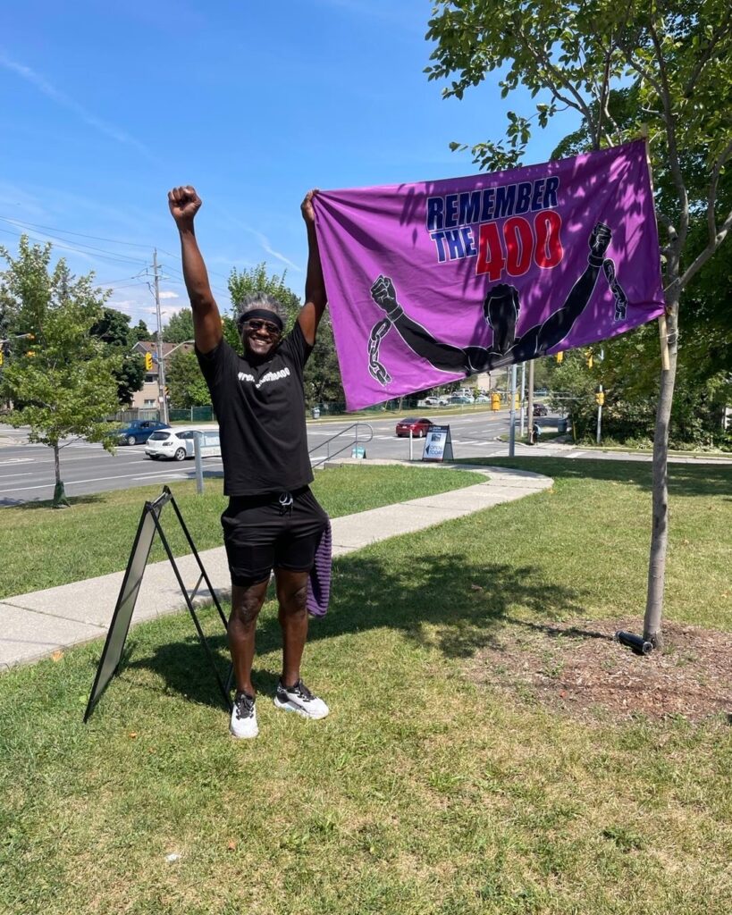 Supporter raising a fist beside the Remember The 400 banner