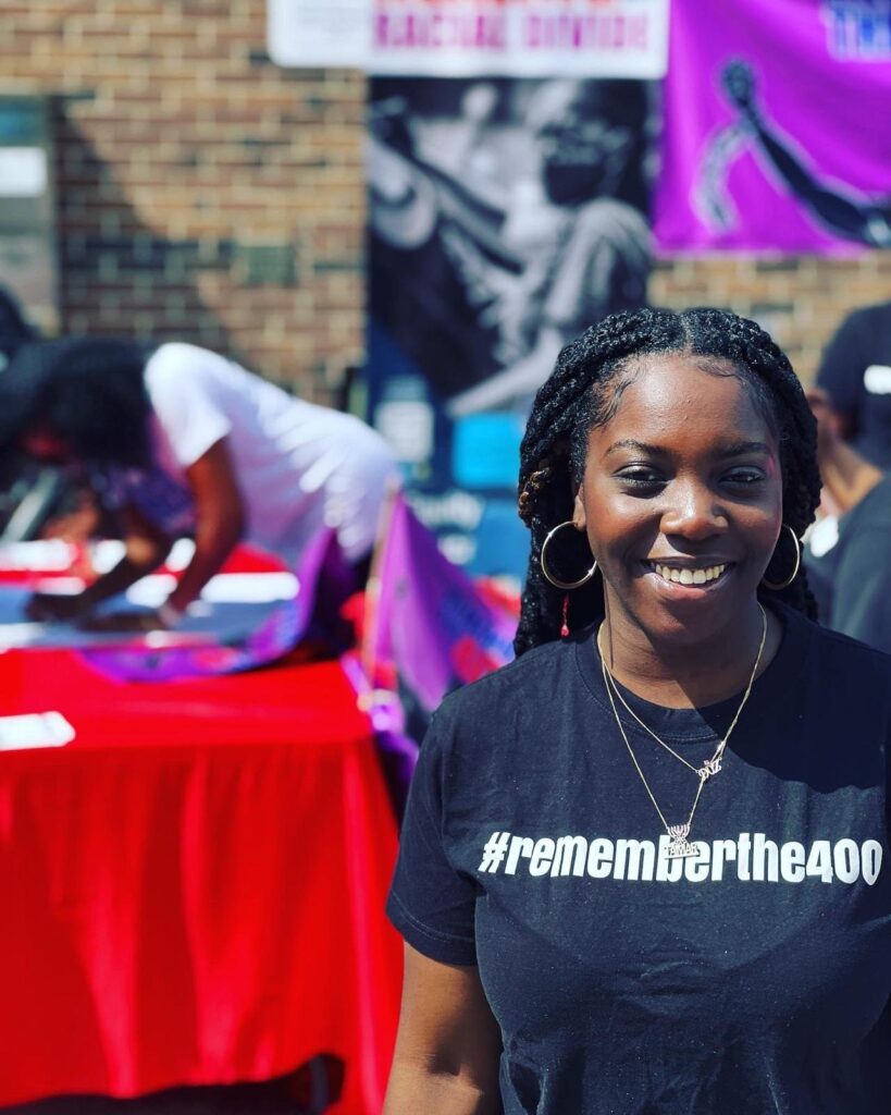 Remember The 400 volunteer at an outreach table